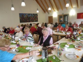Frauenverbände leben Ökumene Frauen unterschiedlichen Alters sitzen bei einem ökumenischen Frauentreffen an einem festlich gedeckten Tisch